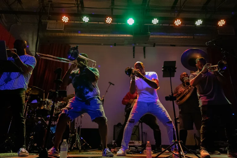 A brass band plays on a stage.