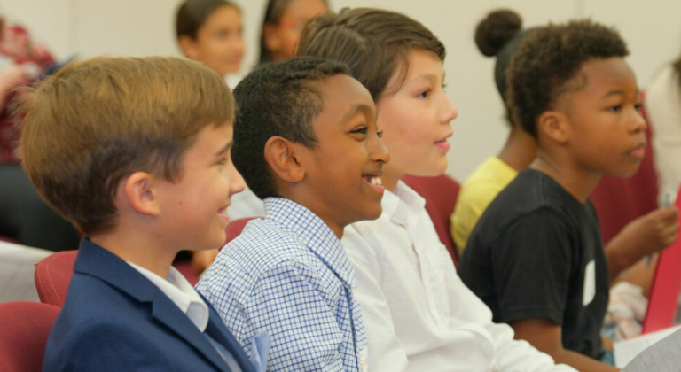 Four elementary students smiling
