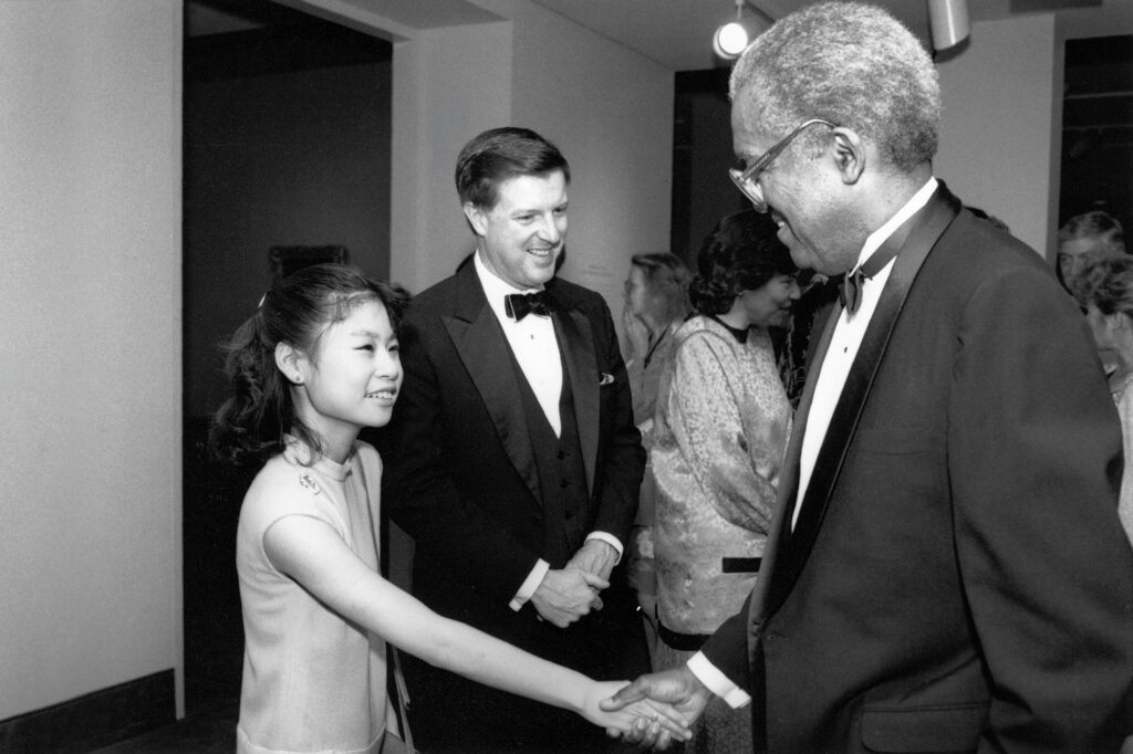 Violinist Midori shaking hands with a fan.